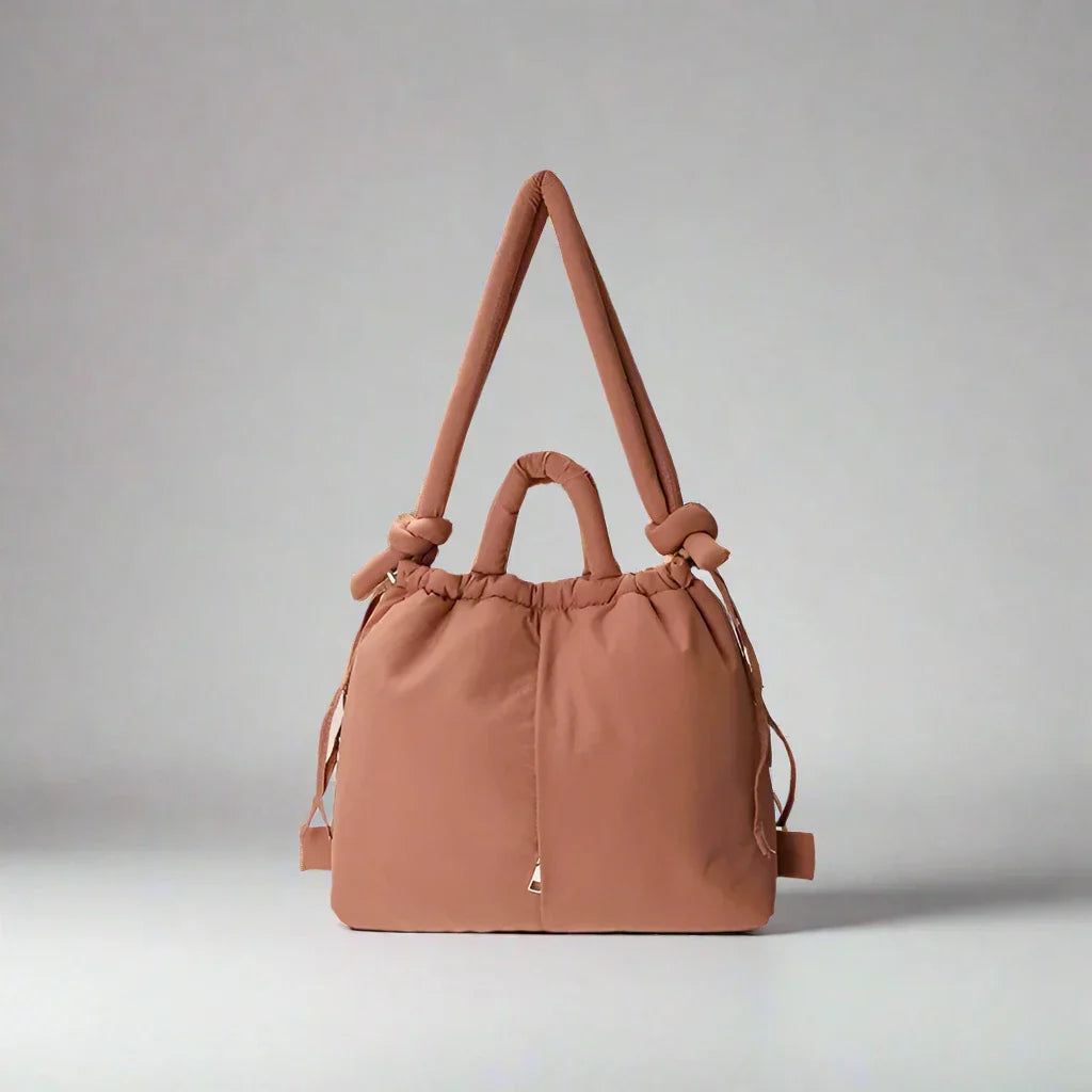 Detail of the stitching on the beige quilted puffer tote bag