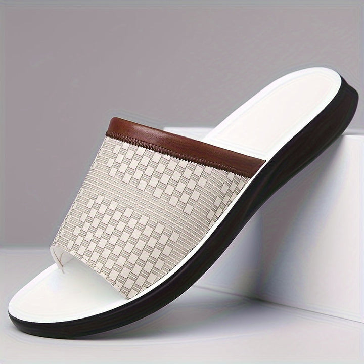 Close-up of men's textured slide sandals, showcasing sophisticated design and comfortable fit. Ideal summer shoes.