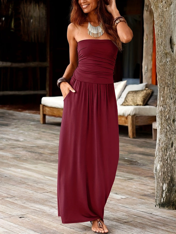 Close-up of the waist-cinching detail on a fashionable women's bandeau midi dress.