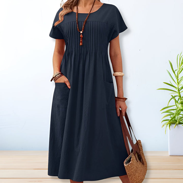 Women's relaxed fit midi dress with short sleeves and practical pockets, perfect for casual summer wear.