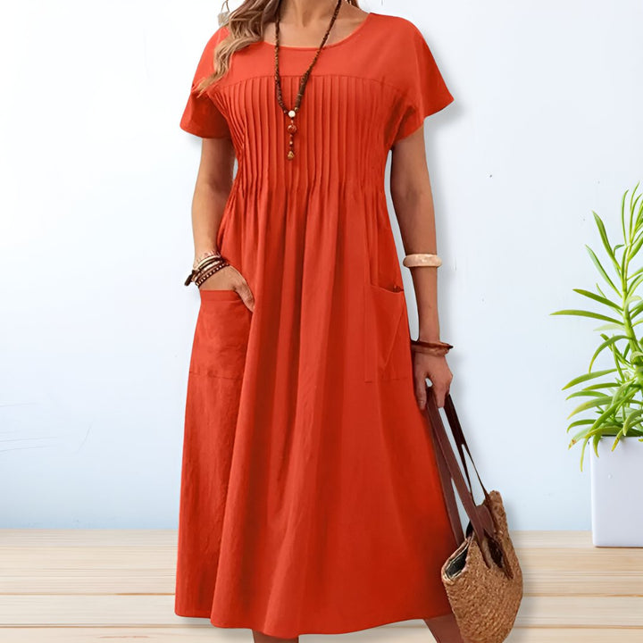 Flowy women's relaxed fit midi dress with short sleeves & pockets, ideal for a comfortable everyday summer look.