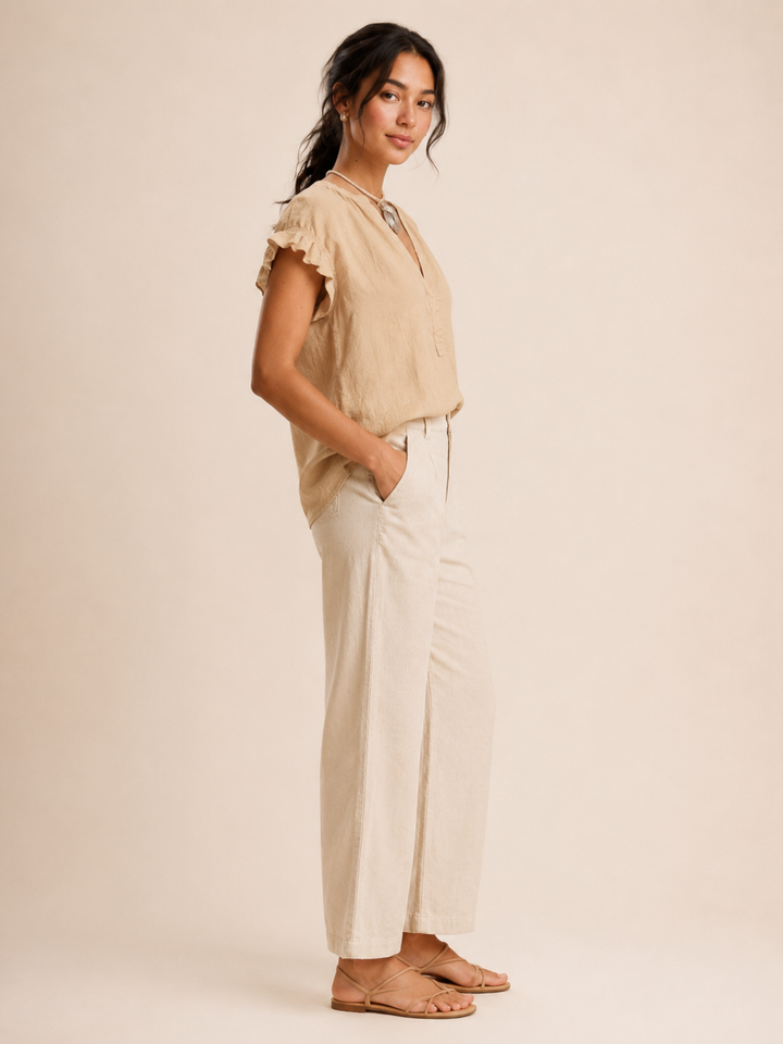Women's elegant white V-Neck Blouse with delicate cap sleeves, perfect for a chic summer outfit.