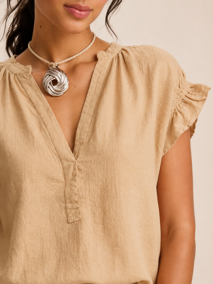 Effortless beige V-neck blouse, featuring timeless ruffle sleeves for relaxed spring style.