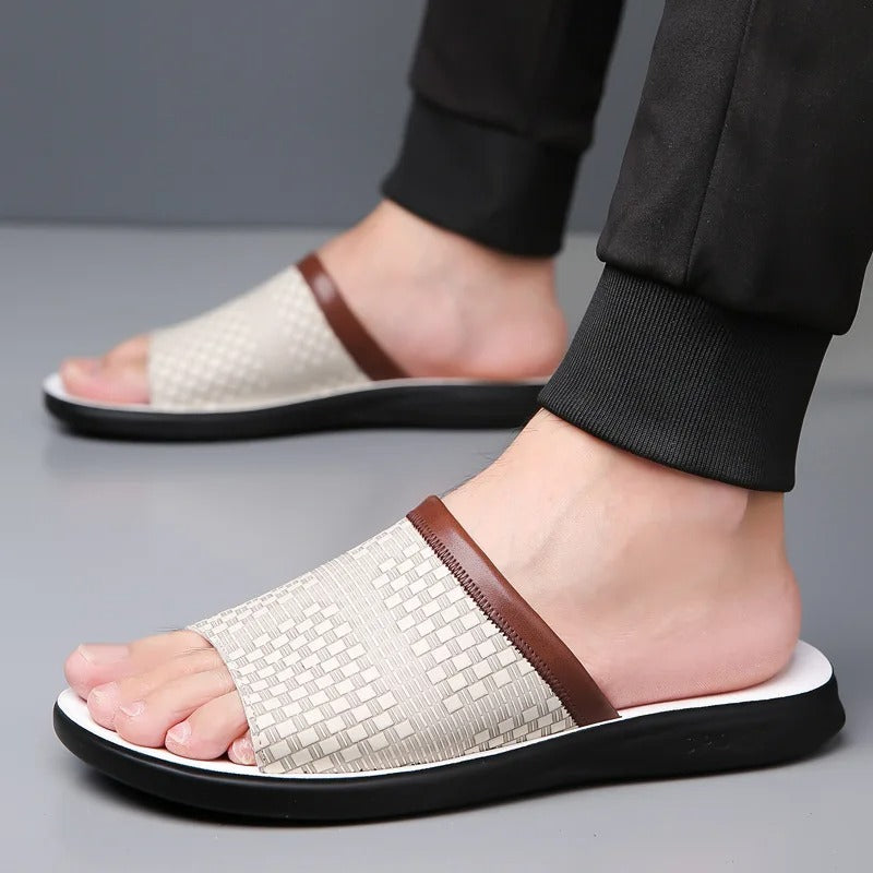 Assortment of men's woven slip-on slides in black, brown, & white, showcasing summer styles.
