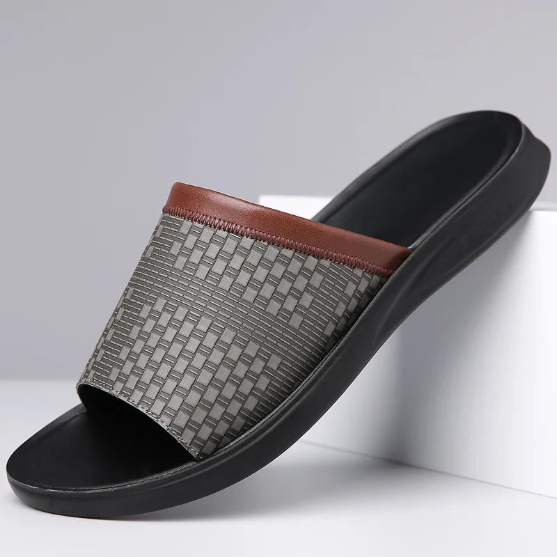 Close-up of black men's slip-on slides showcasing the elegant woven strap texture.