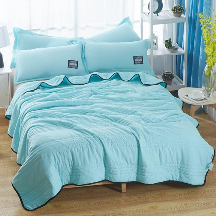 Soft, breathable cooling blanket draped over a bed. Perfect for refreshing sleep & summer comfort.