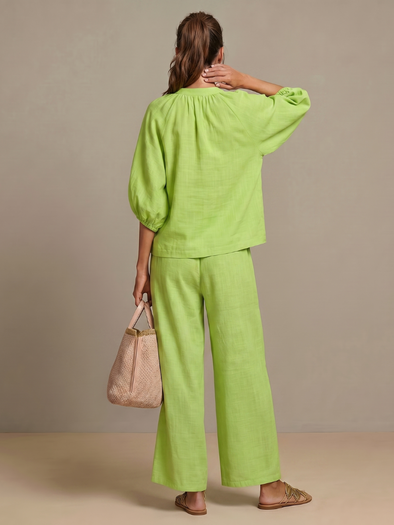 Chic women's zip-front top with blouson style, paired with wide-leg pants.