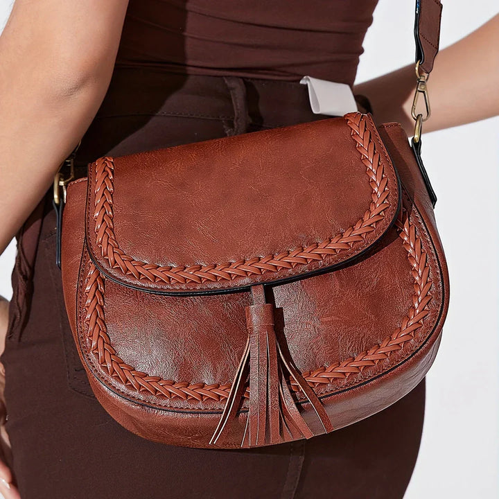 Fashionable women's faux leather shoulder bag with a charming tassel; a stylish accessory.