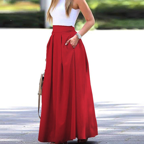 A woman wearing an elegant high-waisted pleated midi skirt, styled for a formal event.