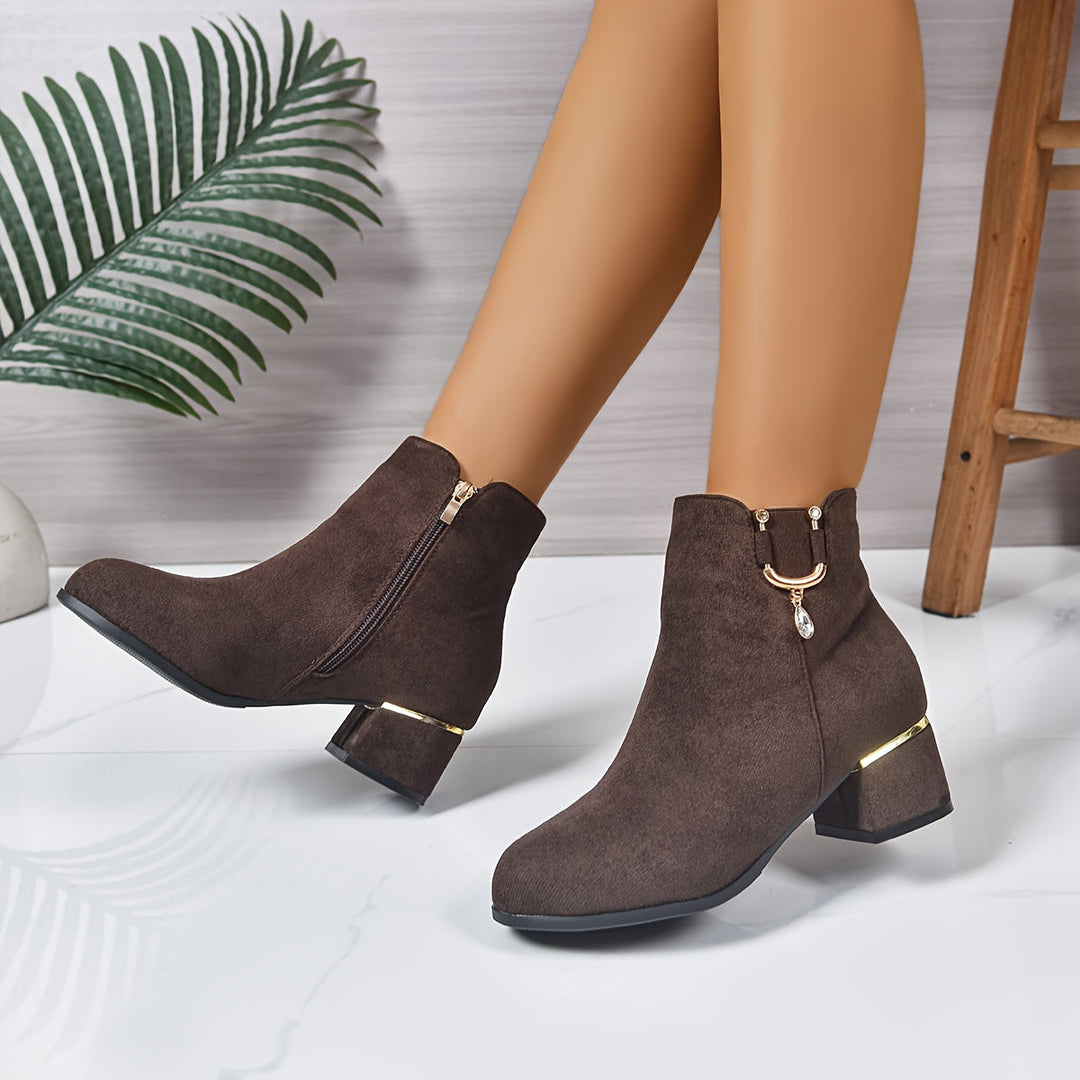 Back view of women's brown Chelsea ankle boots, showing the stable block heel and pull tab detail.