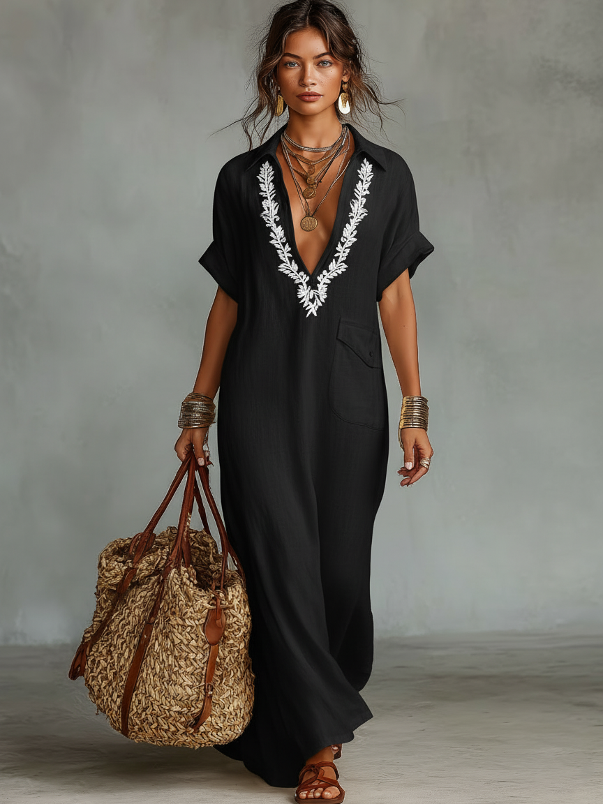 Woman enjoying the beach in a flowy V-neck boho maxi dress with beautiful embroidery. Perfect summer vacation outfit.