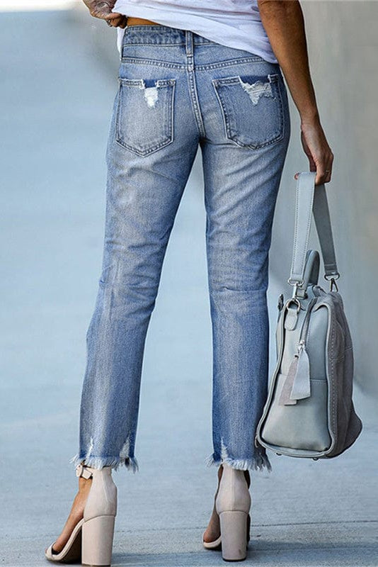 Side view of women's distressed straight leg jeans, featuring a trendy raw hem and mid-rise casual fit.