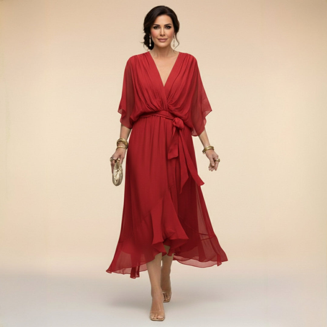 Full shot of a model in a black V-Neck Flowing Midi Dress, showcasing its elegant drape & adjustable waist design.