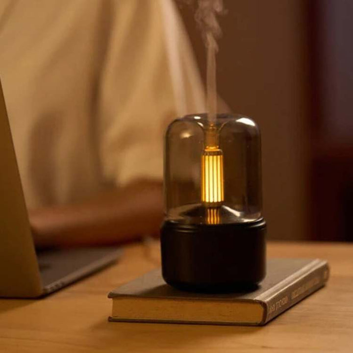 Candlelight essential oil diffuser creating a soothing aroma mist for home relaxation and aromatherapy.