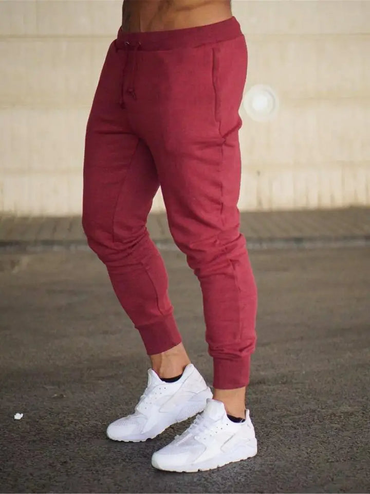 Olive green men's athletic jogger pants, comfortable and loose fit, perfect for activewear and everyday style.