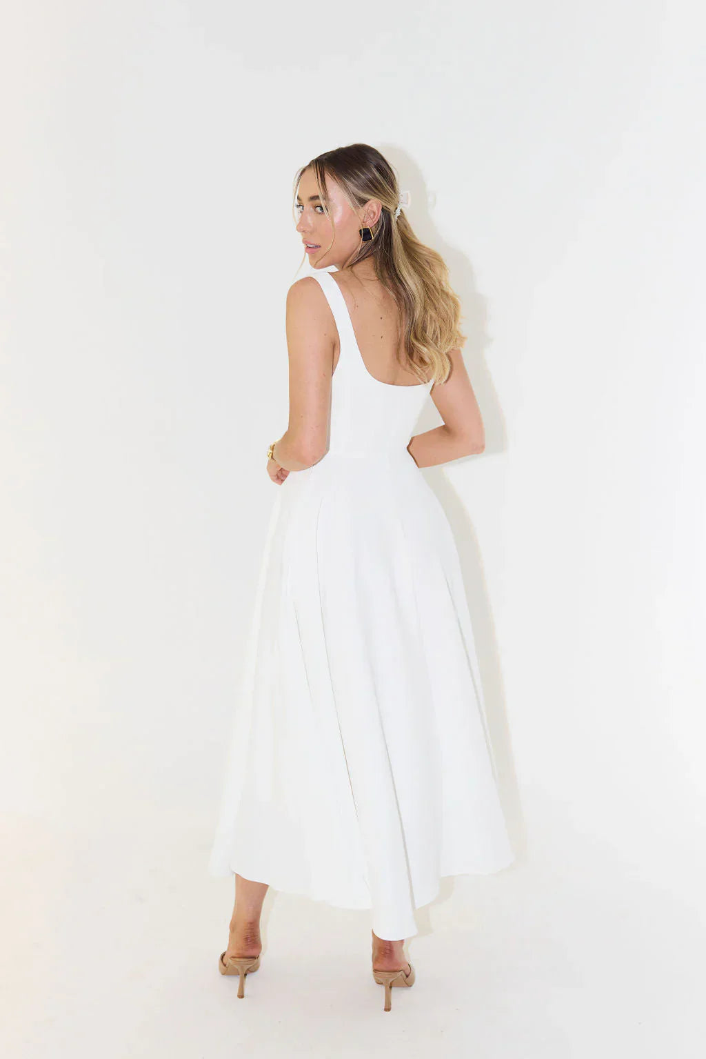 Elegant white sleeveless midi dress, perfect for parties and summer occasions.
