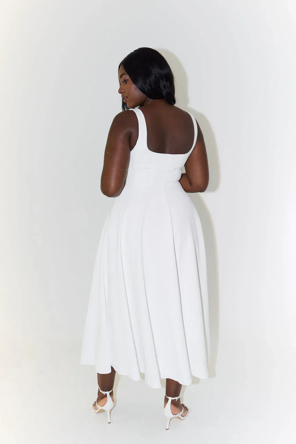 Chic white sleeveless square neck midi dress with a flowing flared skirt.