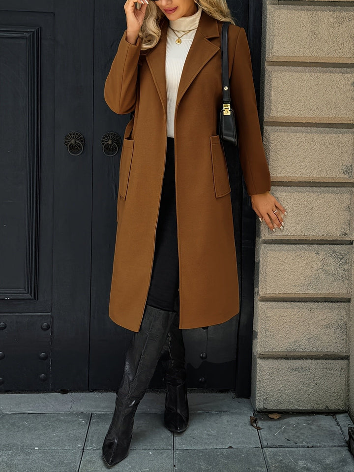 Side view of a women's long trench coat with a belt. Timeless tailored style, versatile for office wear.