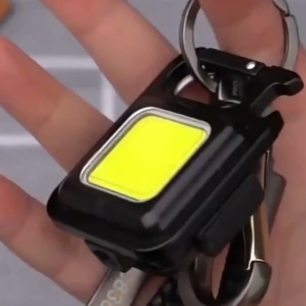Compact aluminum keychain flashlight with powerful COB LED. USB rechargeable & portable utility light.