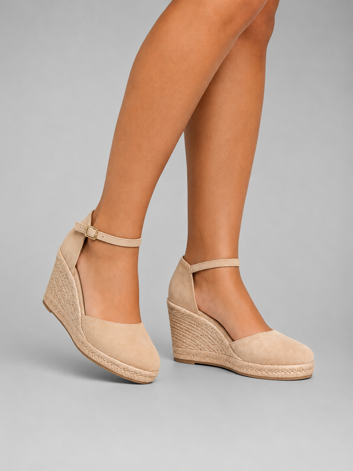 Women's timeless espadrille wedge sandals worn with an ankle strap for a chic summer look.