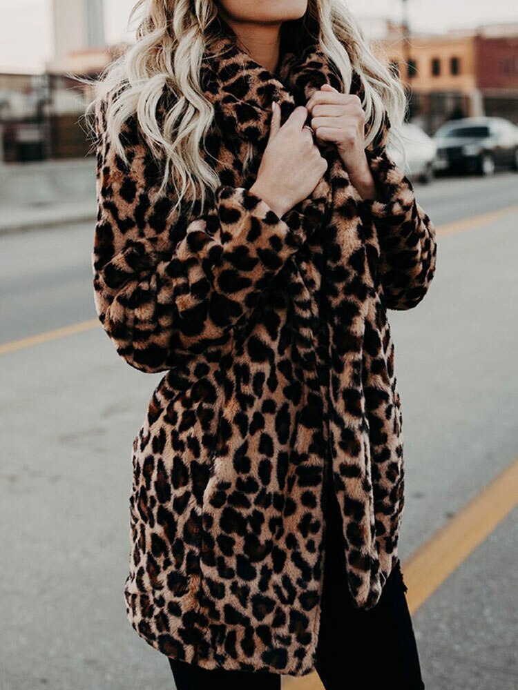 Stylish woman wearing a chic leopard print winter coat, showcasing trendy outerwear and a bold statement piece.