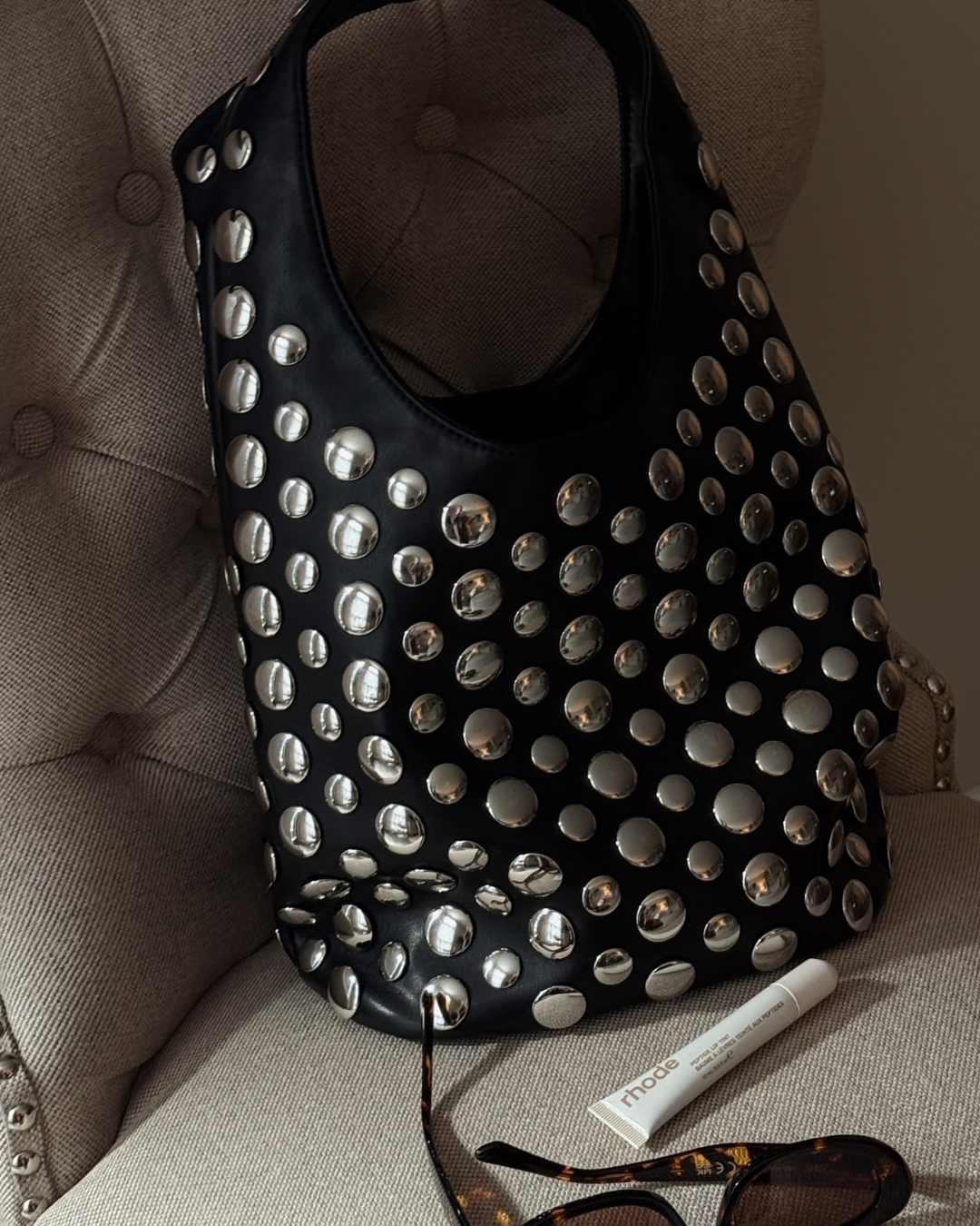 Elegant women's studded shoulder bag with intricate rivet details, perfect as a trendy evening or statement accessory.