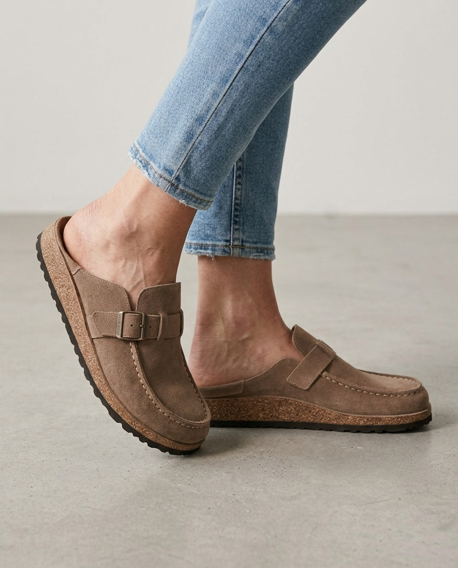 Men's round toe mule clogs featuring stylish buckle detail. Effortless slip-on design & chunky sole.