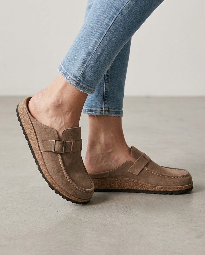 Men's round toe mule clogs featuring stylish buckle detail. Effortless slip-on design & chunky sole.