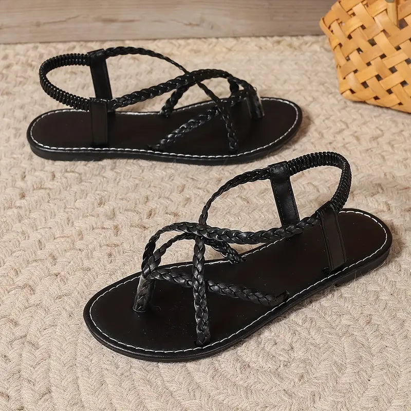 Top view of women's fashionable braided flat sandals with toe ring, essential summer footwear.