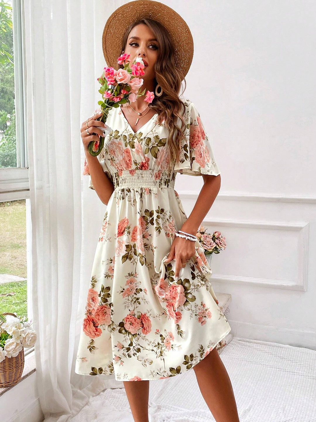 Women's floral midi dress featuring delicate flutter sleeves, V-neckline, and flattering smocked waist.