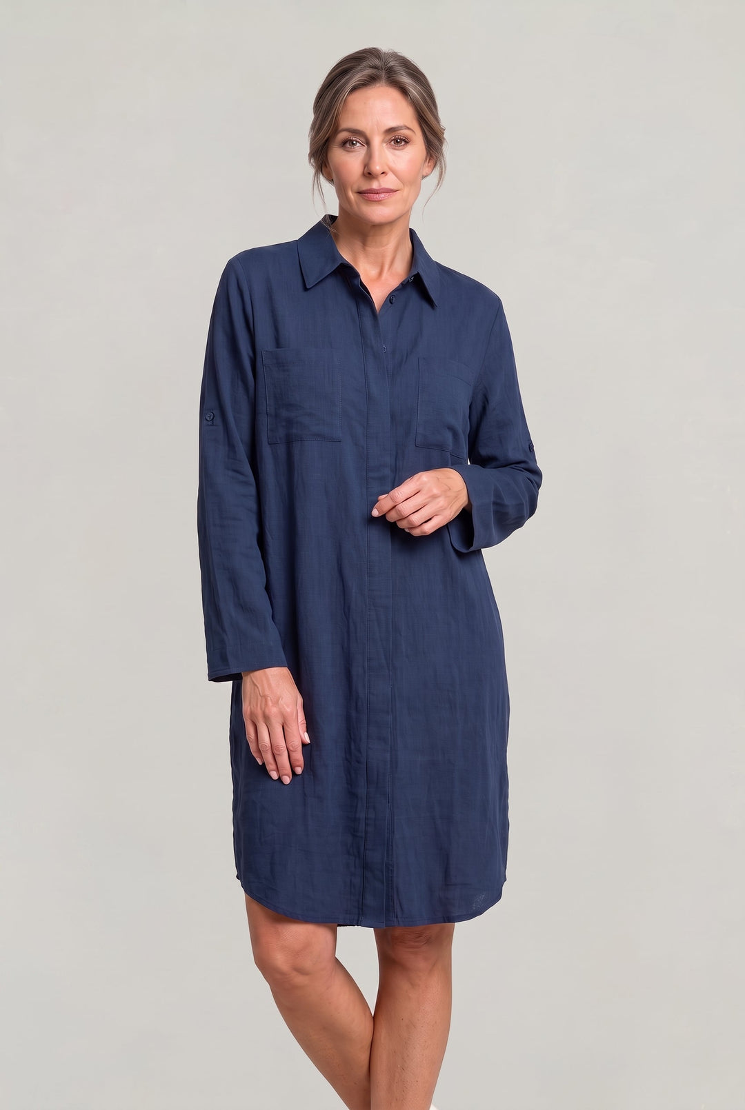 Woman models chic oversized button-down shirt dress, showing relaxed fit and long sleeves, perfect for summer.