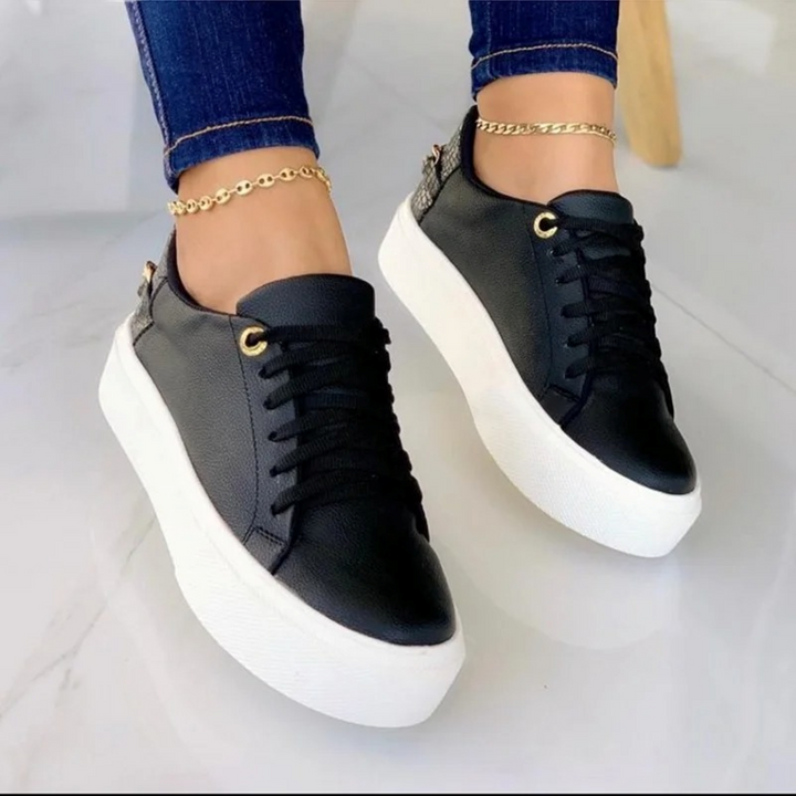 Stylish ComfortStep white leather lace-up sneakers for women, featuring a trendy metallic chain accent.