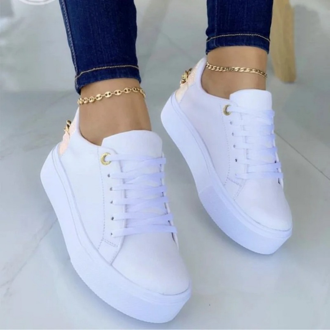 Fashionable white leather sneakers for women by ComfortStep, adorned with a chic metallic chain. Ideal casual footwear.