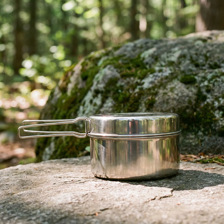 Portable camping mess kit, compact stainless steel cookware nested for easy outdoor travel and backpacking.