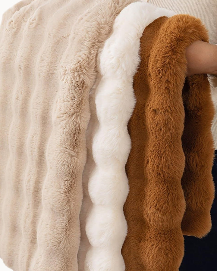 Luxuriously soft white plaid fleece throw blanket, providing cozy warmth for chilly evenings.