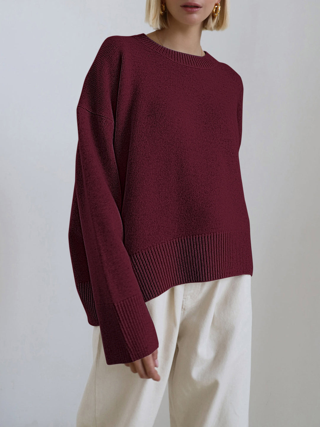 Effortless layering with a soft, oversized knit sweater in a rich burgundy.