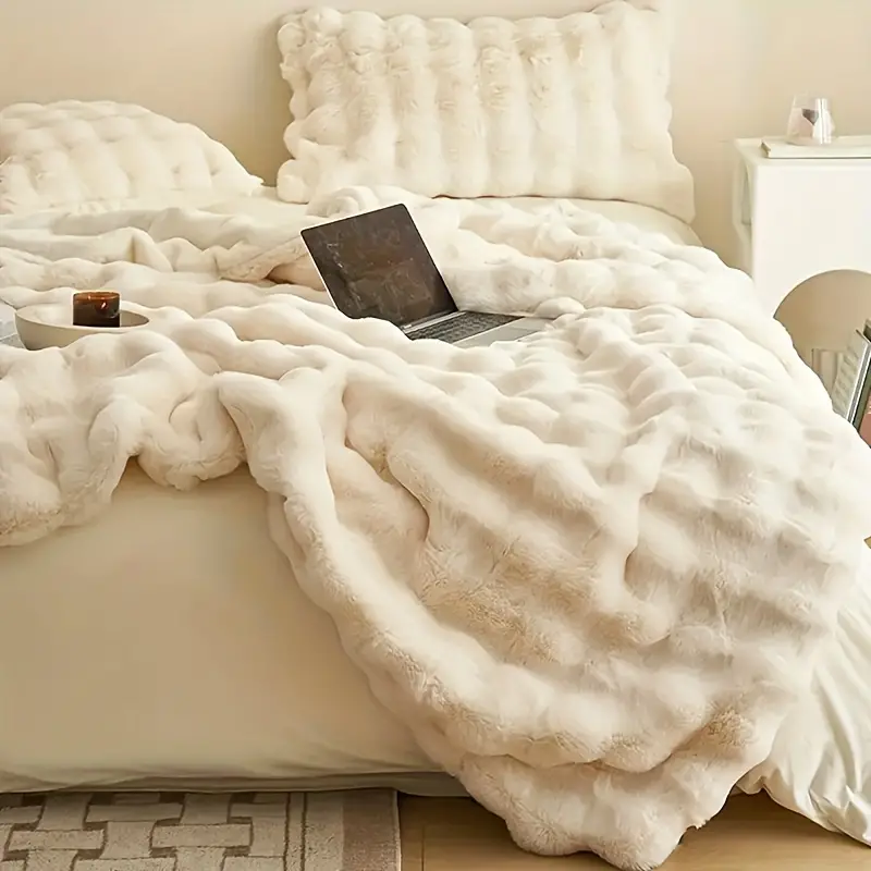 Plush faux fur throw blanket in a neutral tone, providing luxurious softness and warmth for any room.