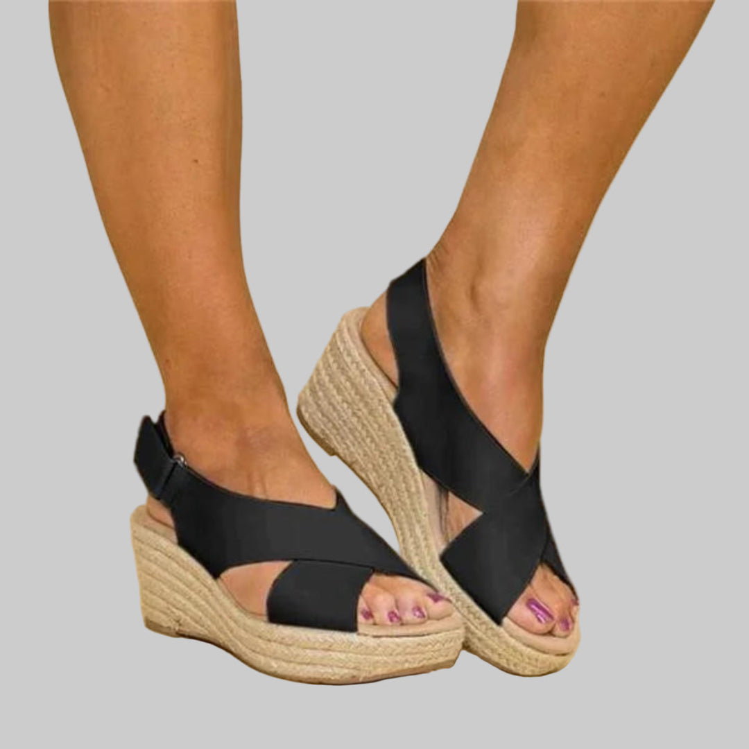 Casual women's open-toe wedge espadrilles featuring crossed straps. Chic and comfortable summer footwear for any occasion.