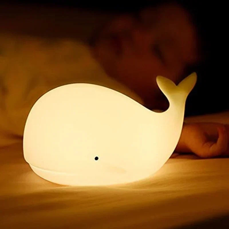 Kids' cute whale LED night light providing a comforting, color-changing glow for a cozy nursery atmosphere.