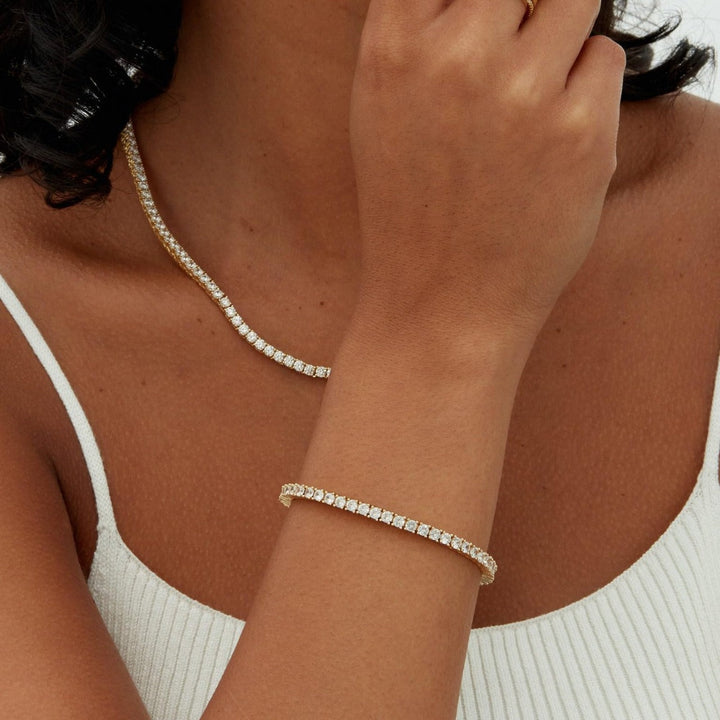 Unisex sparkling single row tennis bracelet in gold, perfect as an elegant fashion accessory or minimalist gift.