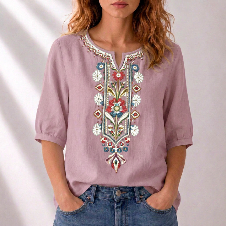 Casual chic women's blouse featuring intricate floral embroidery. Elegant relaxed fit for summer wear.