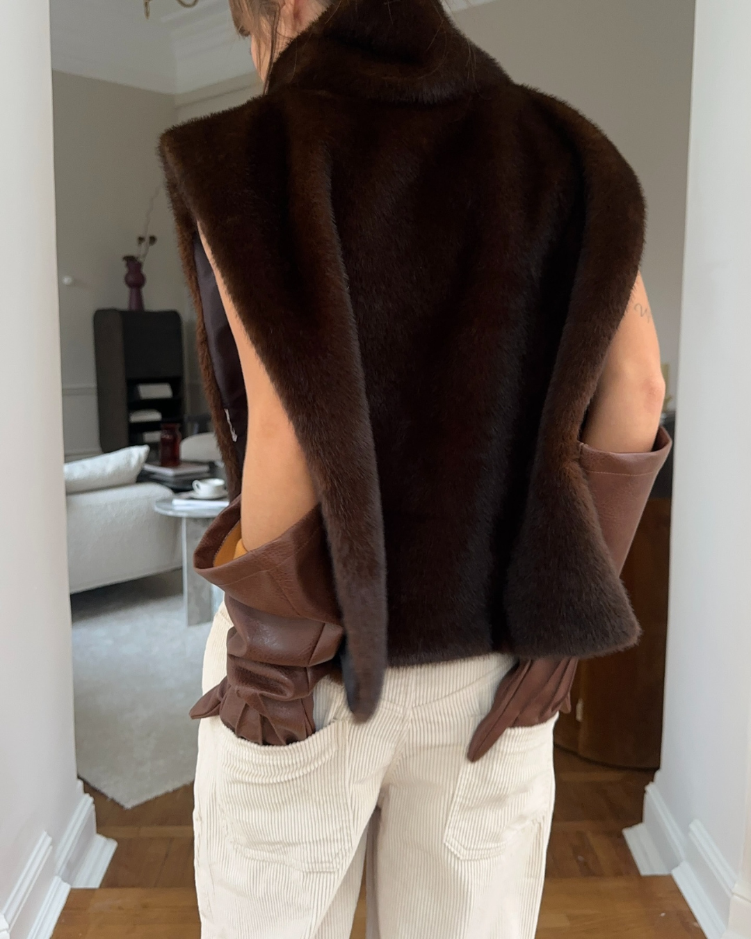 Elegant women's dark brown faux fur vest with a turtleneck, ideal for winter fashion layering.