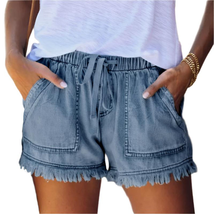 Woman modeling high-waisted fringe hem denim shorts, perfect for a casual, trendy summer look.