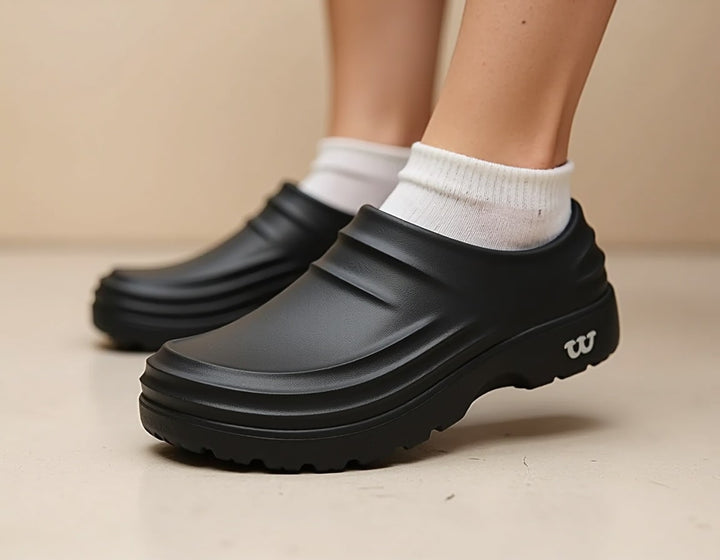 Person wearing black unisex lightweight non-slip comfort clogs, showcasing their casual and comfortable everyday style.