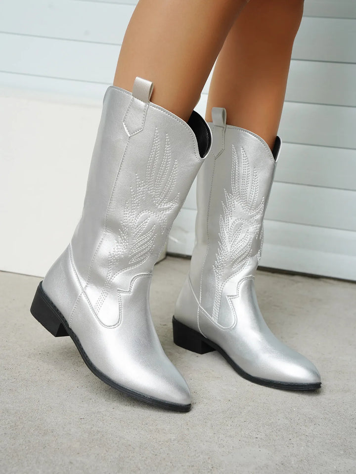 Side profile of women's western boots, elegant stitching detail, pointed toe, fashion footwear.