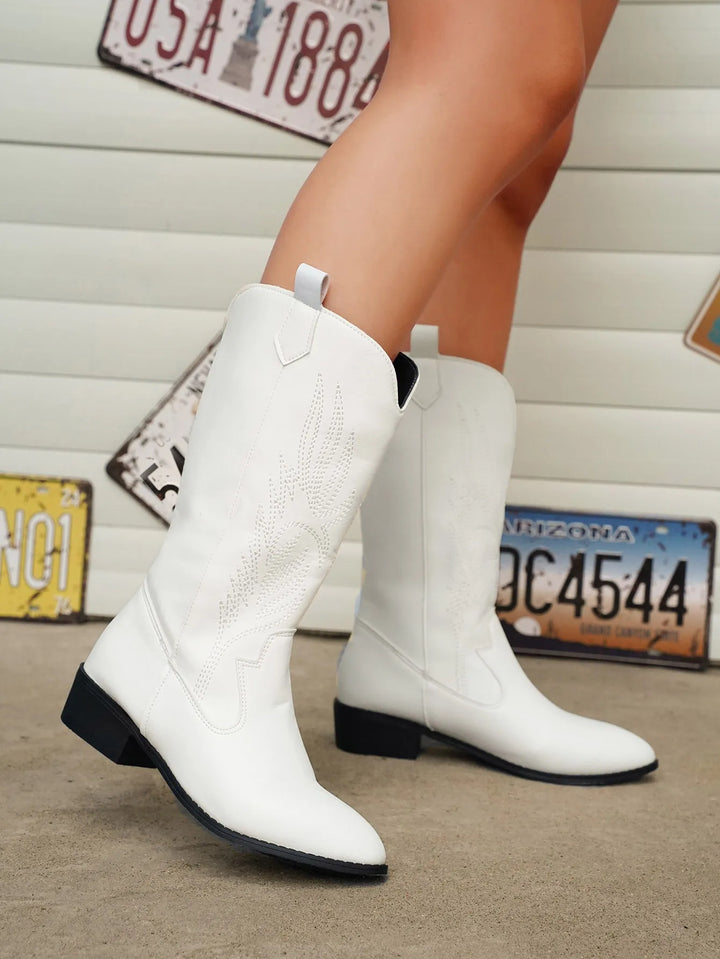 Trendy women's fashion footwear, cowboy boots with elegant stitching and a pointed toe.
