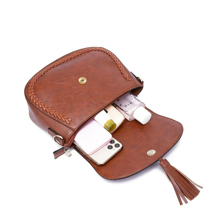 Faux leather shoulder bag for women, featuring a secure zip closure and chic tassel accent.