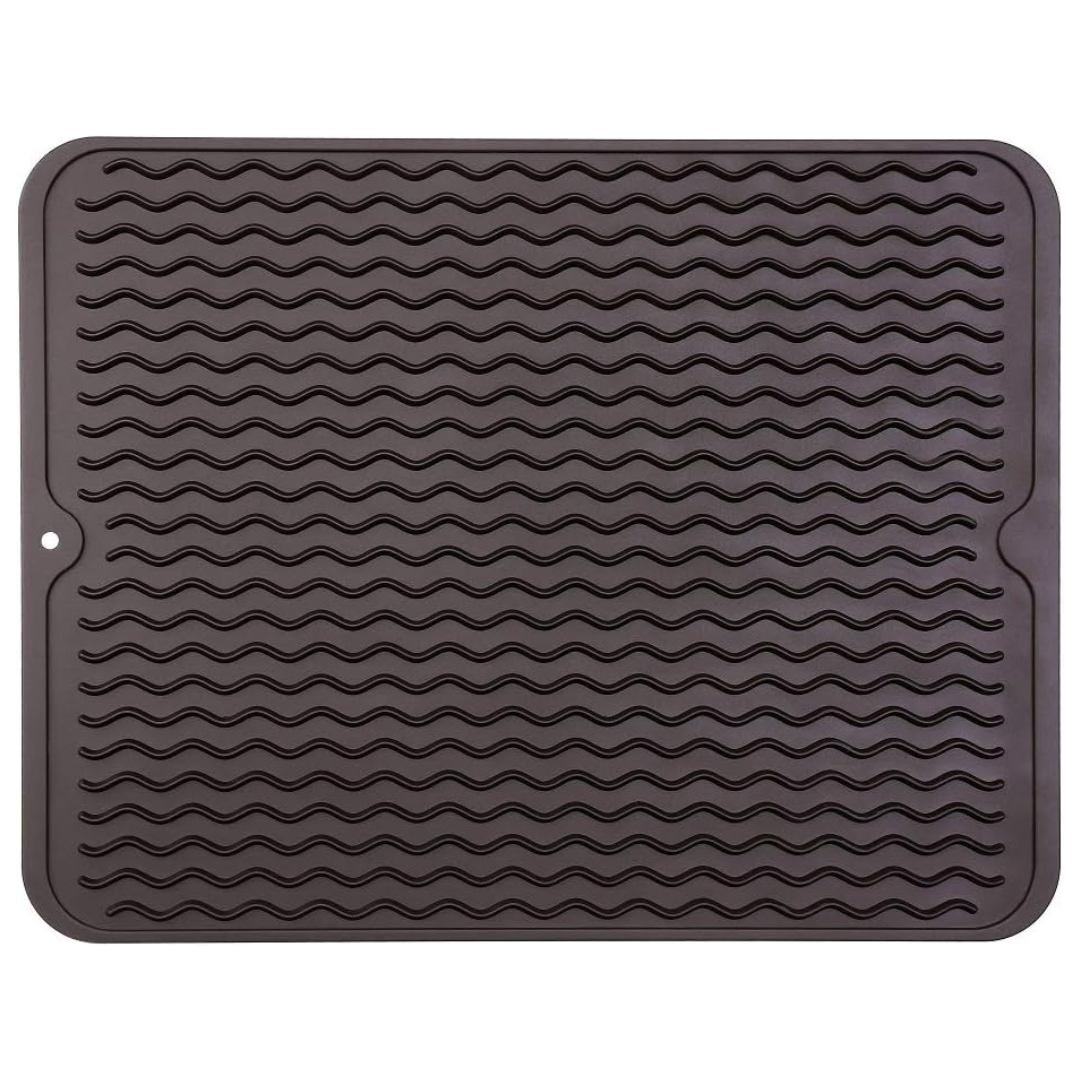 Grooved silicone drying mat for efficient dish drainage on kitchen counters. Also a heat-resistant liner.