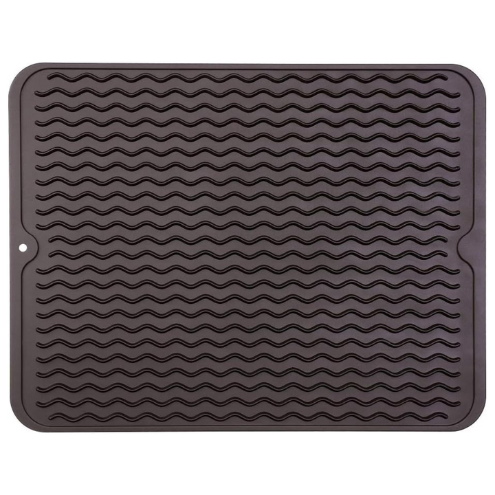 Grooved silicone drying mat for efficient dish drainage on kitchen counters. Also a heat-resistant liner.
