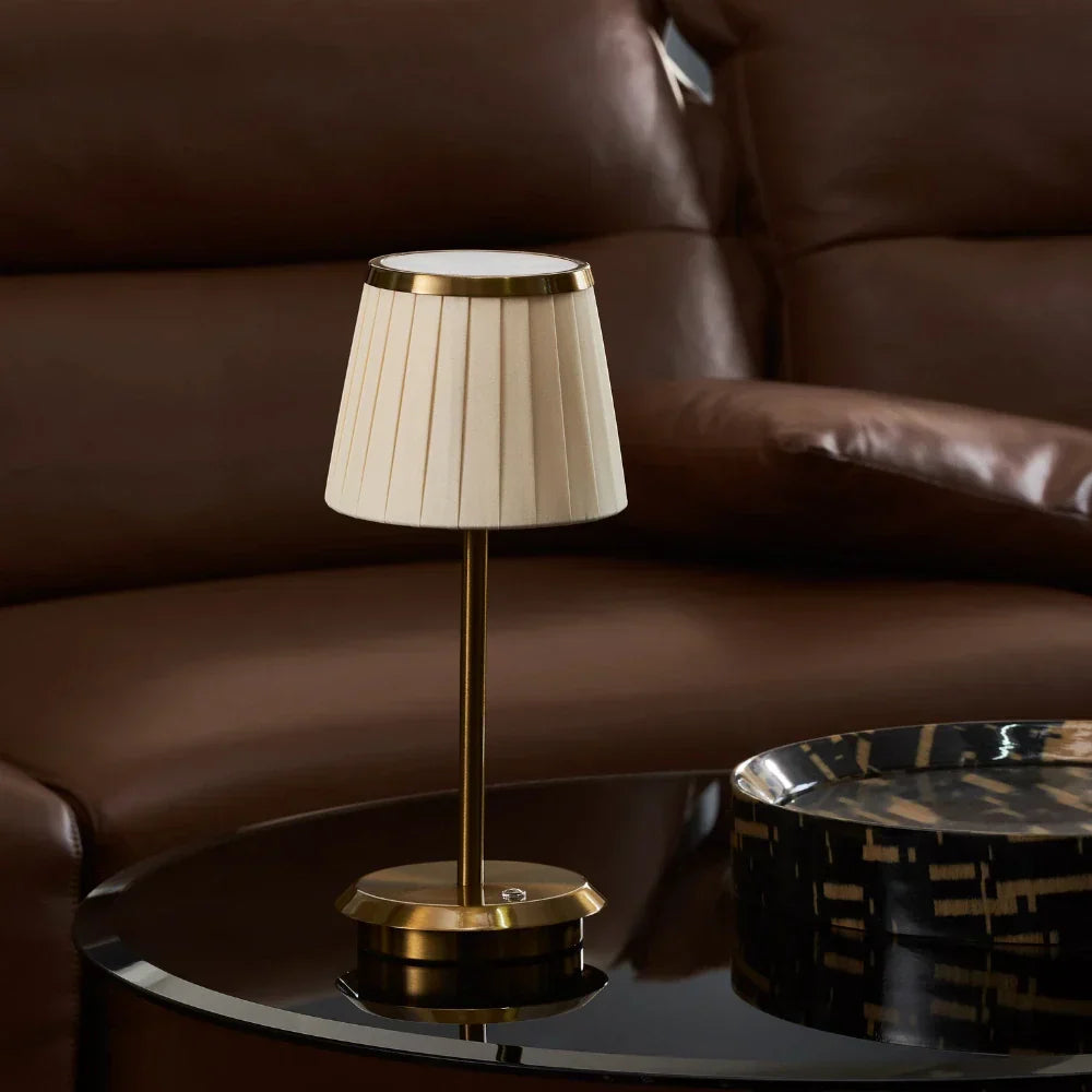 Classic Elegance gold brass table lamp. Refined fabric shade, dimmable LED. Portable modern lighting for any elegant space.